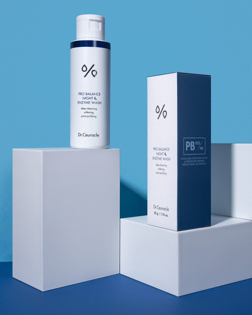 Dr. Ceuracle Pro Balance Night Enzyme Wash bottle and box on white geometric props with a vibrant blue background, showcasing product photography for cosmetics.