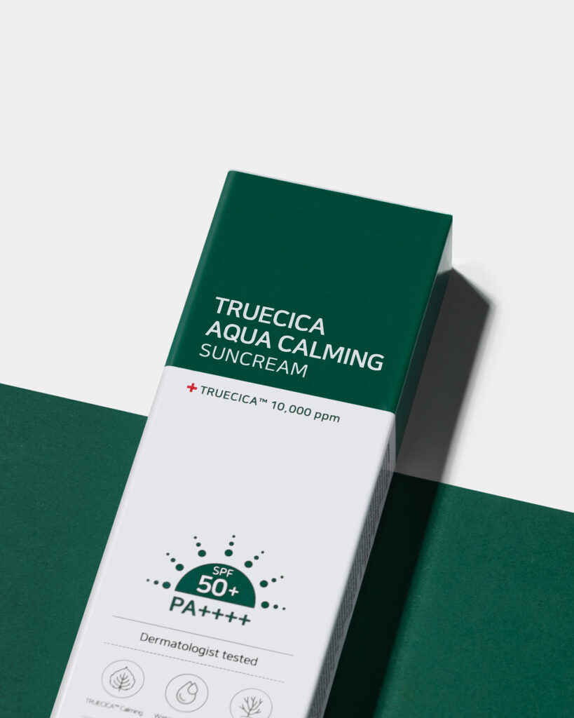 Close-up of the Truecica Aqua Calming Suncream SPF 50+ box, showcasing the white and deep green packaging against a matching monochromatic green background for a clean, minimalist look.