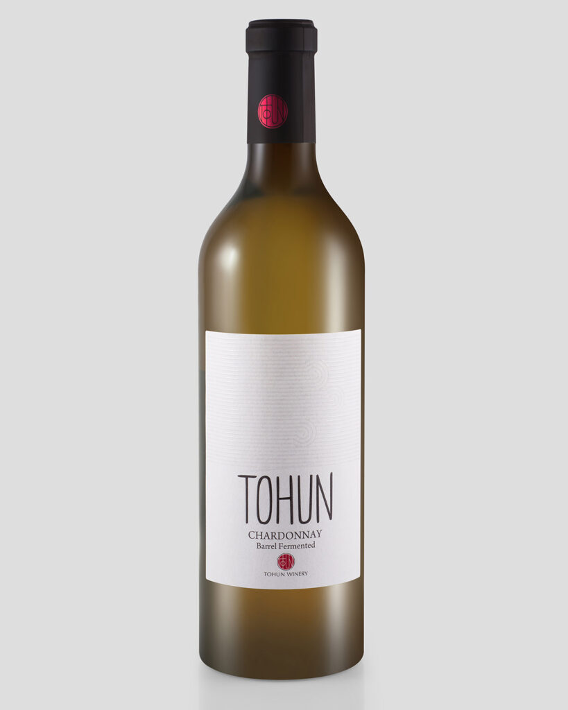 Matte glass bottle of Tohun Chardonnay white wine with a black cap and minimalist white label, professionally photographed on a light grey background.