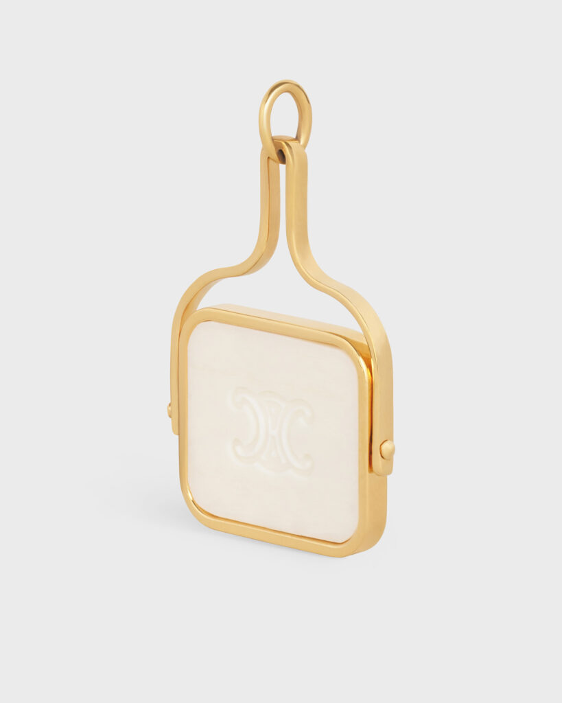 Gold spinning pendant featuring a square inlay of mother-of-pearl or white enamel with the iconic Celine Triomphe logo, photographed for luxury e-commerce.